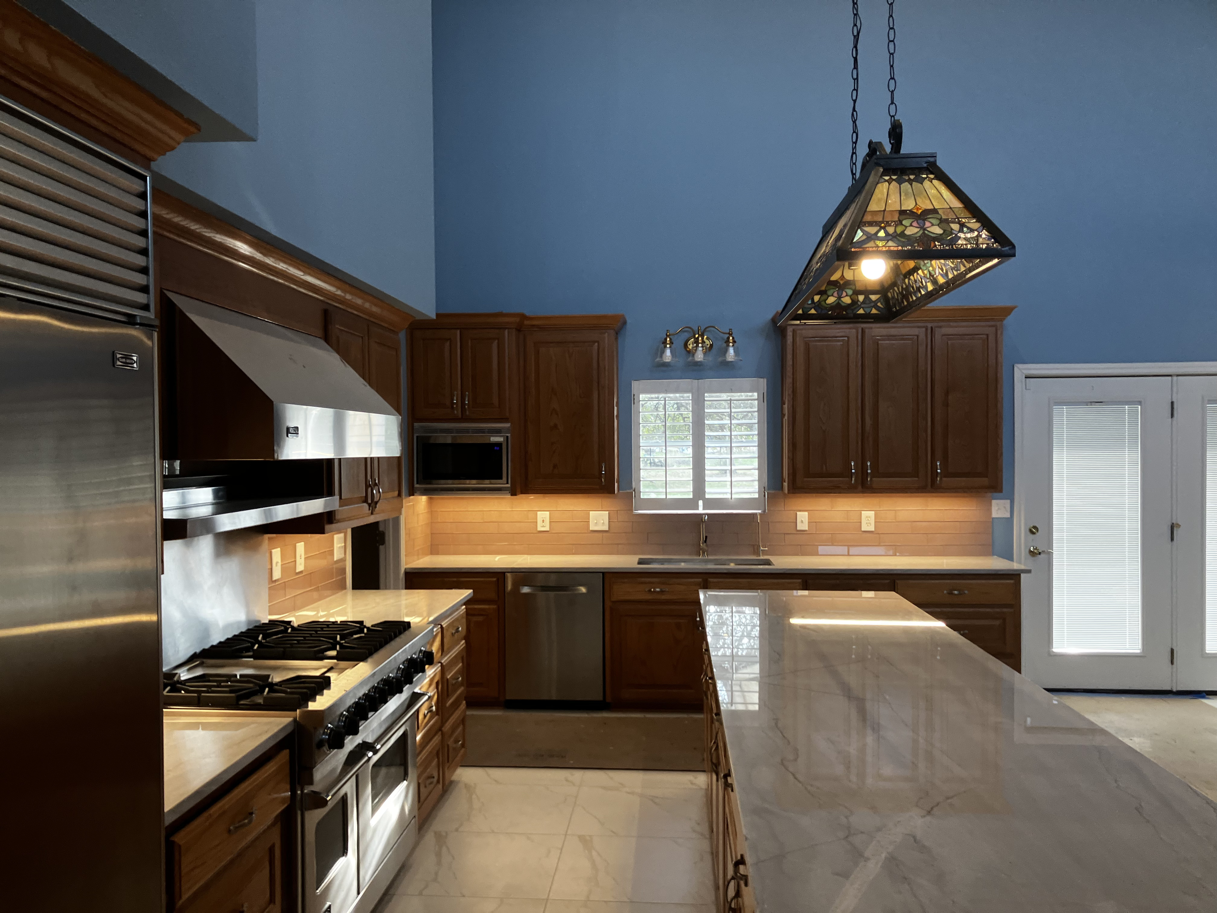 Kitchen with under-cabinet lighting and island chandelier after Wheat Electric lighting work