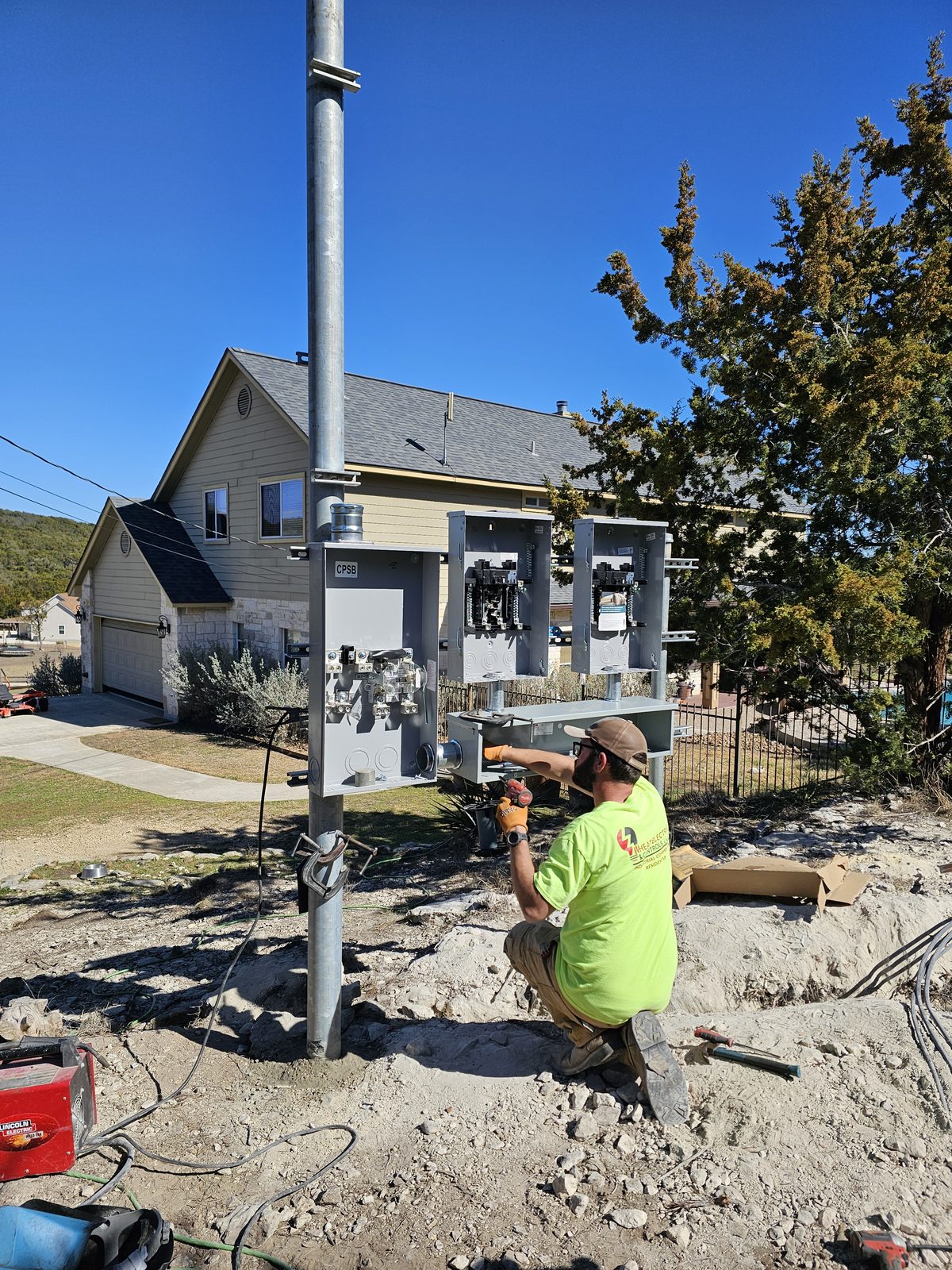 Crew member kneeling at a multi-meter pole with open meter cans