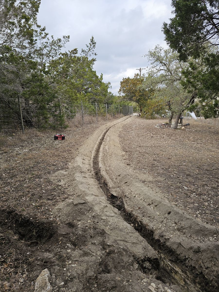 Rocksaw trench dug for underground conduit on a Hill Country property