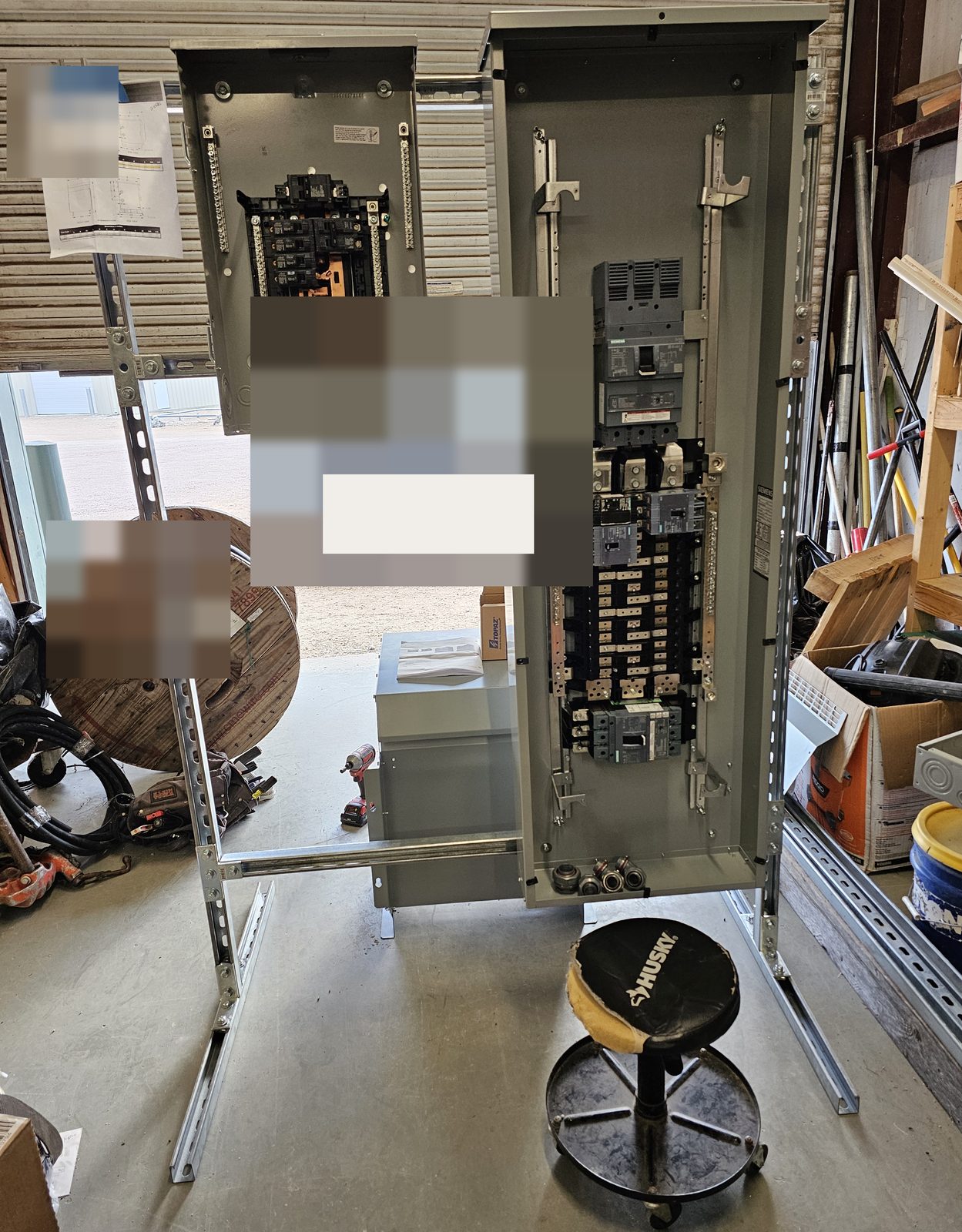 Shop rack with a 400 amp panel and a step-down transformer. The doorway plate is covered.