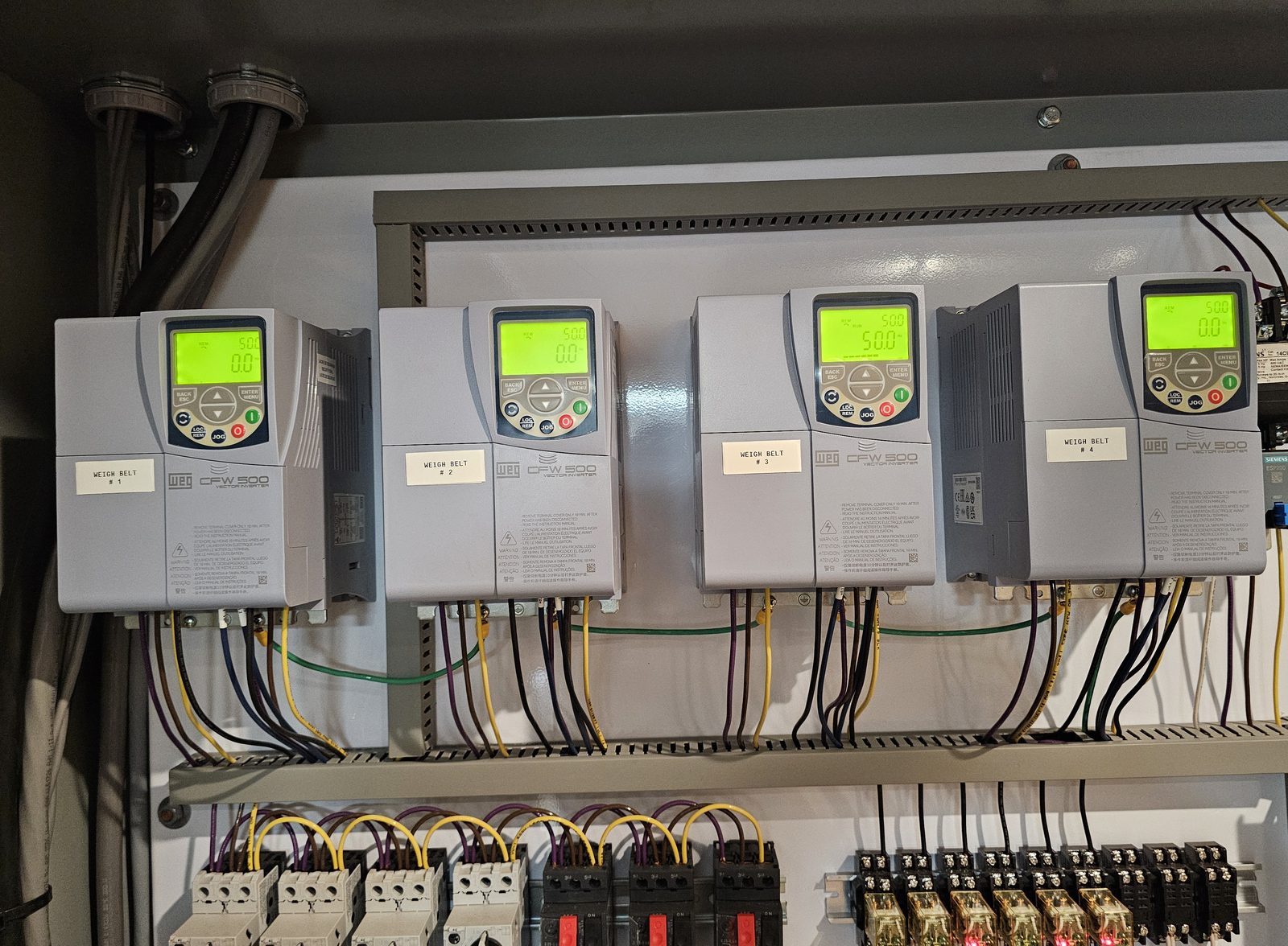 Close-up of WEG CFW500 drives labeled for weigh belts